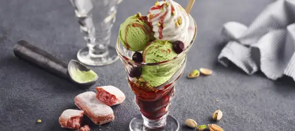 Grön glass med körsbär och visp, toppad med pistagenötter. Ett perfekt pacojet recept för en lyxig dessert.