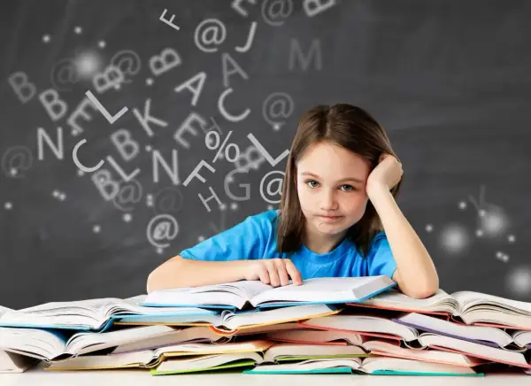 Een meisje met een vermoeide blik zit achter een stapel boeken, omringd door zwevende letters. Ze heeft duidelijk moeite met begrijpend lezen.