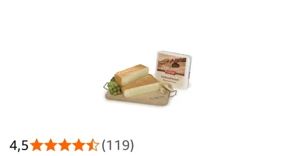 Due fette di formaggio tipo taleggio su tagliere di legno con uva e confezione.
