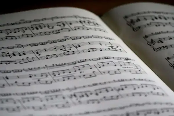 Otwarta księga z nutami, idealna do nauki, jak czytać nuty. Linie i symbole tworzą melodię.