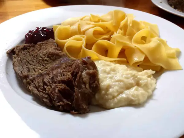 Ein Teller mit deftigem Braten, Bandnudeln, Klößen und Preiselbeeren – ein typisches Hochzeitsessen in Franken.