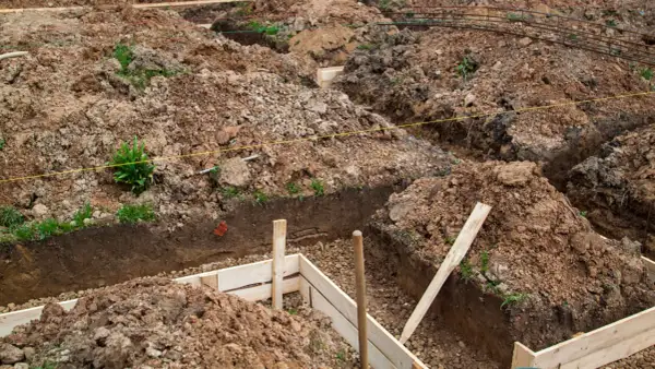 Wykopy pod fundamenty, przygotowane do wylania betonu. Zastanawiasz się, ile kosztuje kopanie fundamentów? To kluczowy etap budowy.