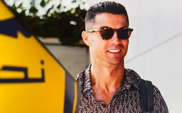 Uśmiechnięty Cristiano Ronaldo w okularach przeciwsłonecznych i wzorzystej koszuli. Zastanawiasz się, ile zarabia Ronaldo na minutę?