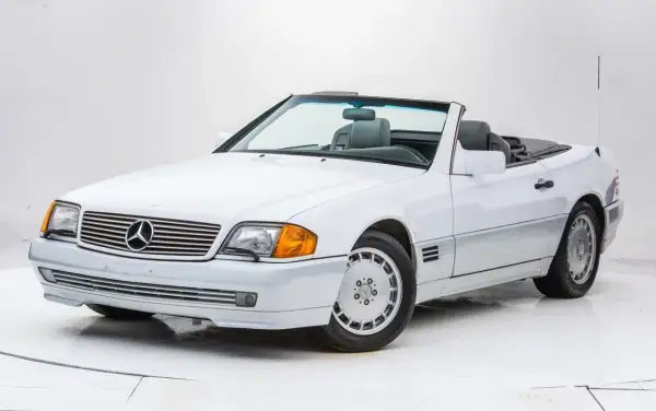Biały kabriolet Mercedes-Benz SL500 z lat 90. z szarym wnętrzem, gotowy na letnią przejażdżkę.