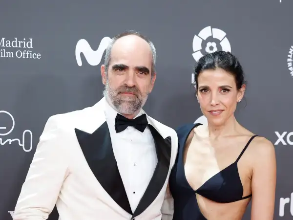 Luis Tosar y su pareja posan en la alfombra roja. Él, con esmoquin blanco y ella, con un elegante vestido negro.