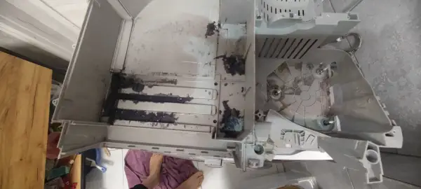 Wnętrze pralki Electrolux z błędem E20, widoczne resztki prania i brud.