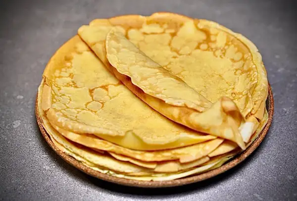 Pile de crêpes dorées et moelleuses, parfaites pour une recette facile.