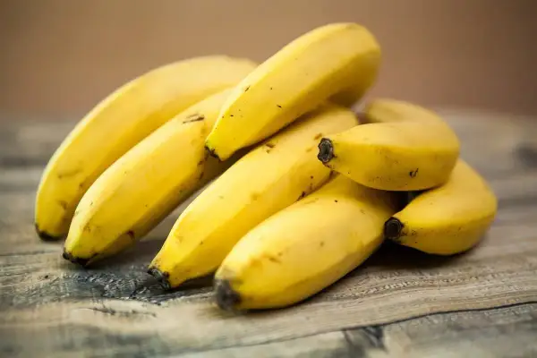 Kupka żółtych bananów na drewnianym blacie. Czy banany są zdrowe? Tak, to pyszna i pożywna przekąska!
