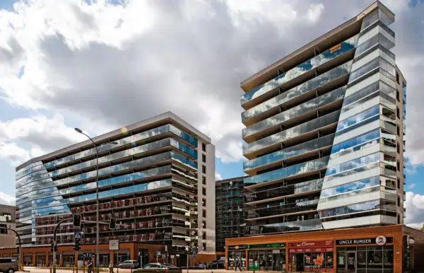 Nowoczesne apartamentowce z przeszklonymi fasadami odbijają chmury. Zastanawiasz się, dlaczego deweloperzy nie podają cen?