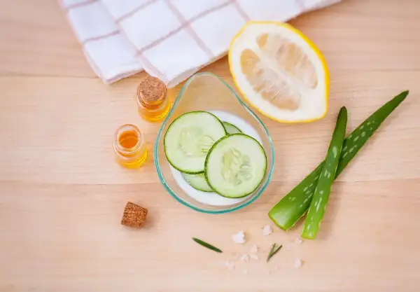 Natürliche Zutaten für ein Beauty-Tag zuhause: Gurkenscheiben, Aloe Vera, Zitrone und Öle.
