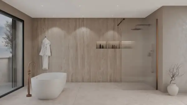 Élégante salle de bain beige et blanc avec baignoire îlot, douche vitrée et peignoir blanc suspendu.