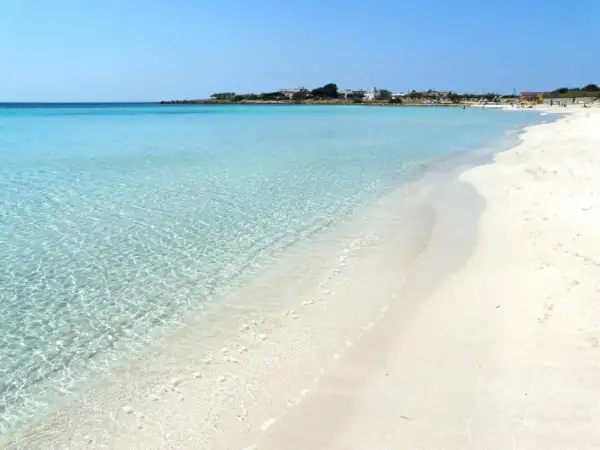 Spiaggia di Porto Cesareo con acque cristalline e sabbia bianca. Un paradiso per rilassarsi sotto il sole.