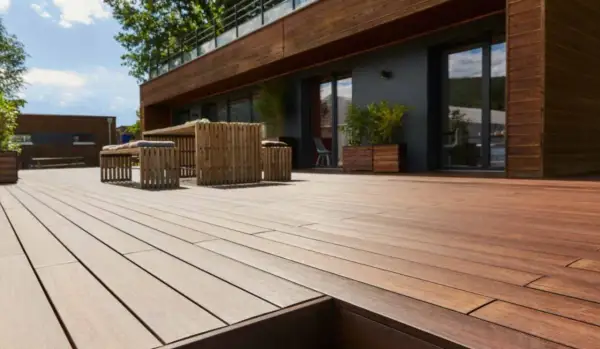 Terrazza in legno con mobili da esterno. La posa a secco, meglio sabbia o ghiaia, garantisce stabilità e drenaggio.