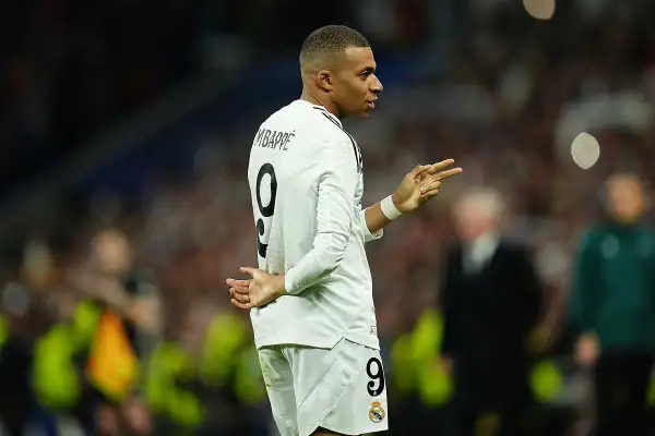 Mbappé w białej koszulce z numerem 9, gestykuluje, jakby świętował urodziny.