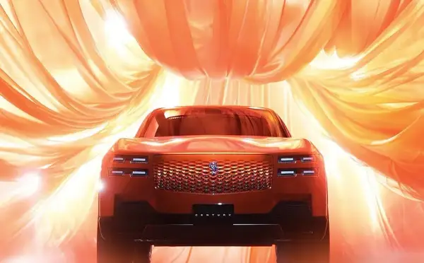 Nowy Toyota Century w pomarańczowym odcieniu, otoczony falującymi, złotymi tkaninami, prezentuje swoją luksusową kratę i reflektory.