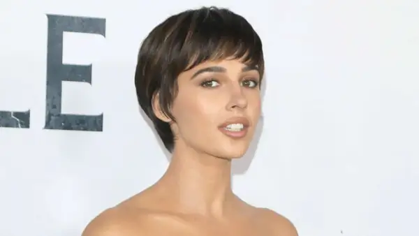 Naomi Scott, mit ihrem markanten Kurzhaarschnitt, strahlt auf dem roten Teppich. Ihre Augen, so klar wie ein christlicher Glaube, fesseln den Betrachter.