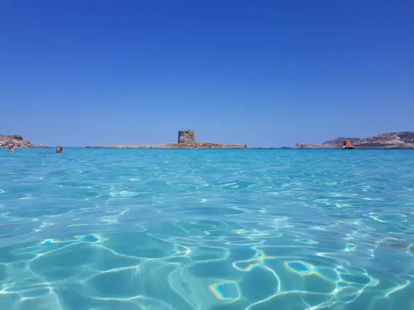 Acque cristalline e un'antica torre in mezzo al mare: uno dei tanti posti di mare belli in Italia.