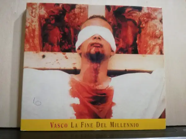 Copertina di "Vasco La Fine Del Millennio" con un uomo bendato e sanguinante, immagine disturbante che evoca la fine di un'era.