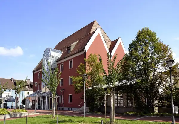 Das Handwerksmuseum Deggendorf präsentiert sich in einem modernen Gebäude mit auffälliger Glasfront und roten Fassaden.