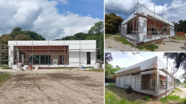 Casa moderna en construcción, con andamios y materiales. Saber que valen los permisos para construir una casa es clave para este proyecto.
