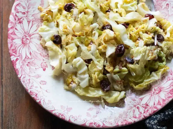 Verza in padella con uvetta, un contorno saporito e colorato servito su un piatto decorato.