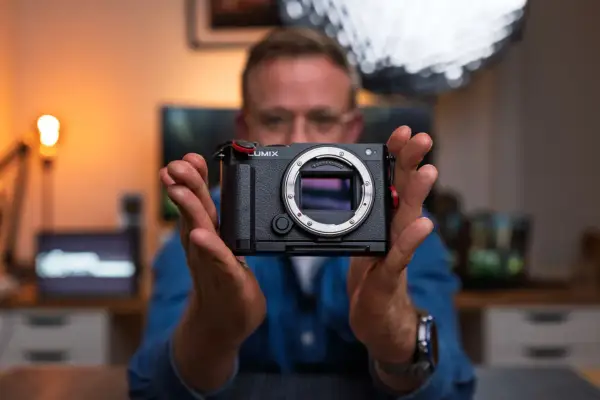 Mężczyzna trzyma aparat Lumix, gotowy do uchwycenia każdej chwili. To jego pelna klatka marzeń.