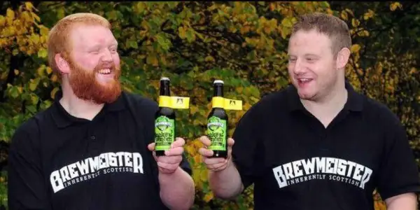 Due uomini sorridono tenendo bottiglie di birra. Potrebbe essere la birra più alcolica del mondo, prodotta da Brewmeister.