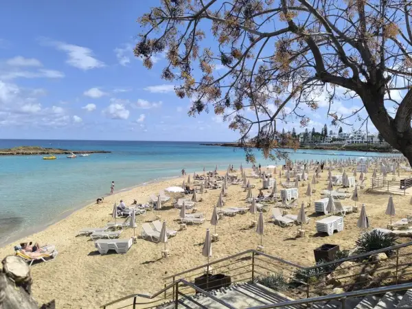 Piękna plaża na Cyprze, z turkusową wodą i rzędami leżaków. To jedno z najpiękniejszych miejsc na wyspie.