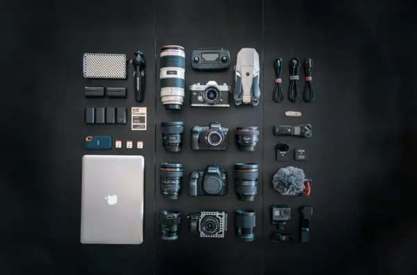 A filmmaker's dream setup, showcasing a serious case of gear acquisition syndrome: cameras, lenses, drone, laptop, and audio gear laid out.