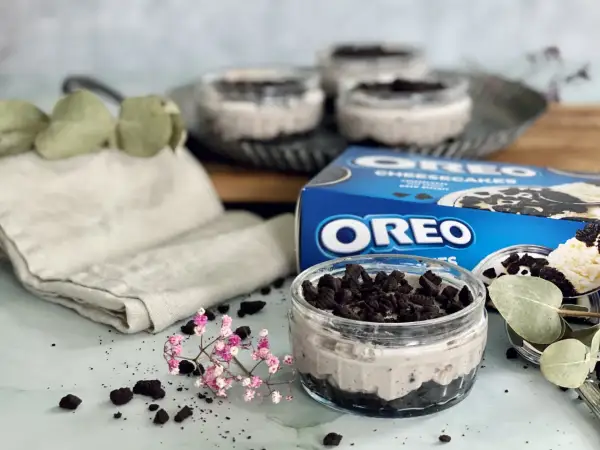 Leckeres Oreo Rezept: Cremige Desserts im Glas, garniert mit zerbröselten Keksen und frischen Kräutern.