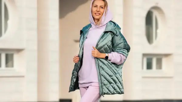 Kobieta w pastelowym dresie i błyszczącej kurtce. Idealny zestaw, który udowadnia, że botki do dresów to świetny wybór na co dzień.