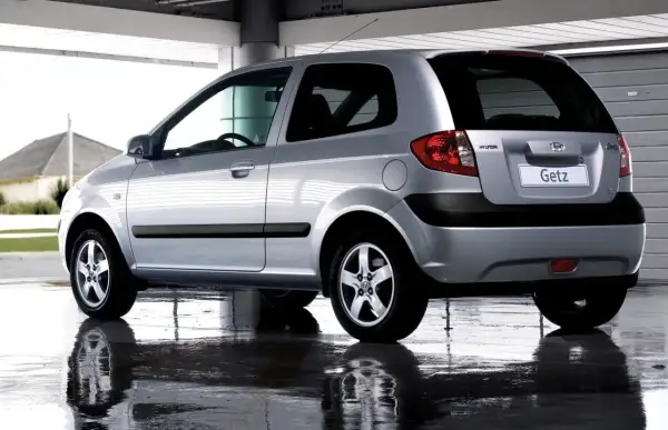 Srebrny Hyundai Getz 1.1 z 2005 roku, widok z tyłu, stoi na mokrej nawierzchni.