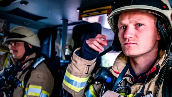 Zwei Feuerwehrmänner in voller Montur, bereit für den Einsatz. Die Serie "Feuer und Flamme Staffel 10" zeigt ihren Alltag.