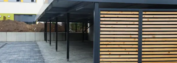 Moderne Holzlamellen verkleiden den Carport und schaffen eine ansprechende Optik.