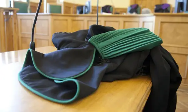 Toga adwokacka na stole w sali sądowej. Zastanawiasz się, ile zarabia adwokat z urzędu?