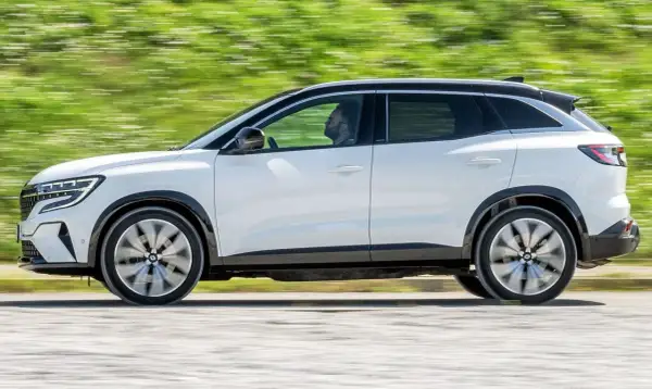 Biały Renault Austral w ruchu, z widocznym kierowcą. Jego dynamiczna sylwetka i nowoczesne linie podkreślają jego wymiary.