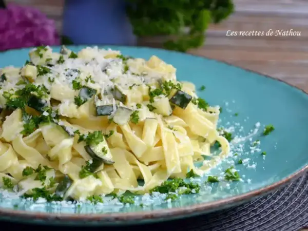 Assiette de tagliatelle de courgette crémeuse, parsemée de persil frais et de parmesan râpé. Un délice léger et savoureux.