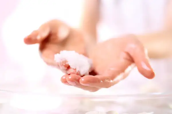 Zwei Hände halten eine kleine Menge eines selbstgemachten Peelings. Perfekt zum Handpeeling selber machen zum Verschenken.