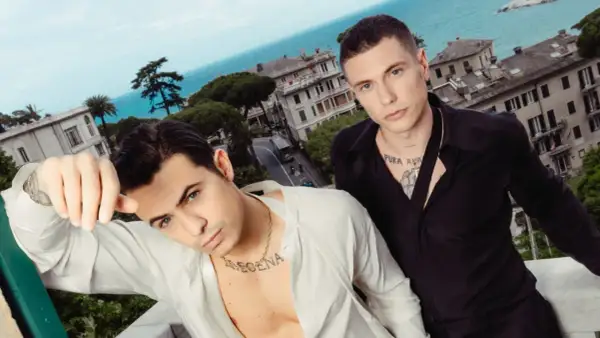 Benji e Fede posano con un panorama mozzafiato alle loro spalle, tra case colorate e il blu del mare.