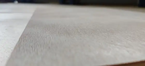 Textura de madera de okume arbol, con vetas finas y claras, mostrando la belleza natural del material.