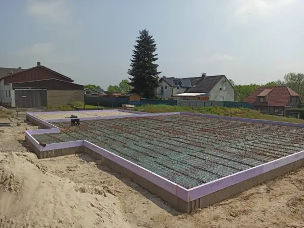 Fundament pod dom w Niemczech, gotowy do zalania betonem. Praca na budowlance trwa.