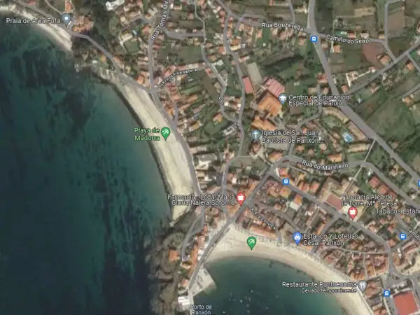 Vista aérea de la **playa de Madorra**, con el mar turquesa y la arena dorada. Se aprecian edificios y calles cercanas.