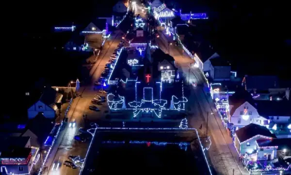 Nocne Popowo rozświetlone tysiącami światełek. Kościół i domy ozdobione świątecznymi iluminacjami tworzą magiczny widok.