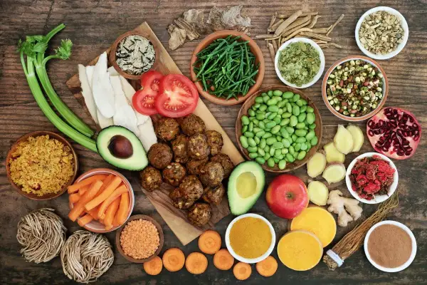 Variedad de alimentos saludables, algunos considerados **reflujo alimentos prohibidos**, como tomates y aguacate, junto a legumbres, verduras y especias.