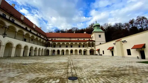 Dziedziniec zamku Sucha Beskidzka z arkadowymi krużgankami i wieżą.
