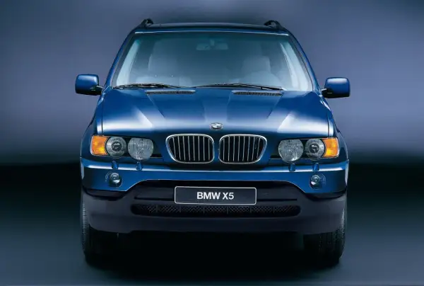 Niebieski BMW X5, pierwszy SUV tej marki, znany z wiki. Klasyczna krata i okrągłe reflektory.