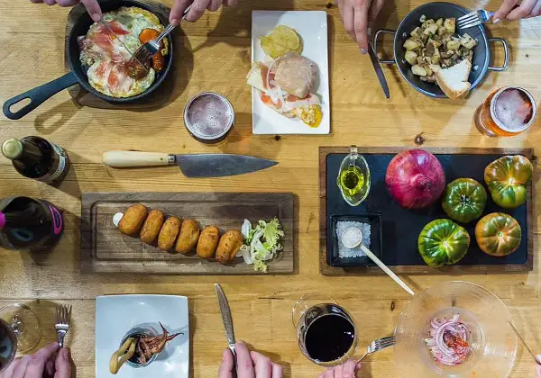 Una mesa llena de delicias para una ruta tapas: croquetas, montadito, huevo con jamón, patatas y calamares. ¡Buen provecho!