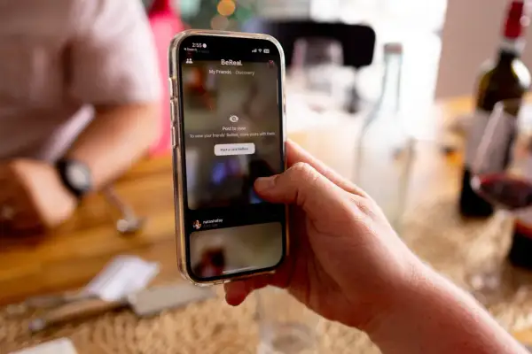 Dłoń trzyma telefon z aplikacją BeReal. To platforma, która zachęca do dzielenia się autentycznymi chwilami.