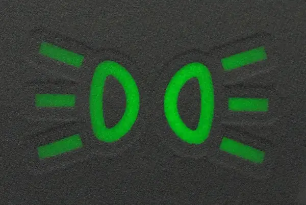 Zielony symbol świateł mijania na ciemnym tle.