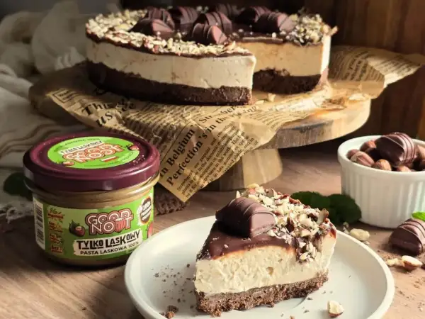 Pyszne ciasto z mascarpone, udekorowane czekoladą i orzechami. Obok słoik pasty z orzechów laskowych.